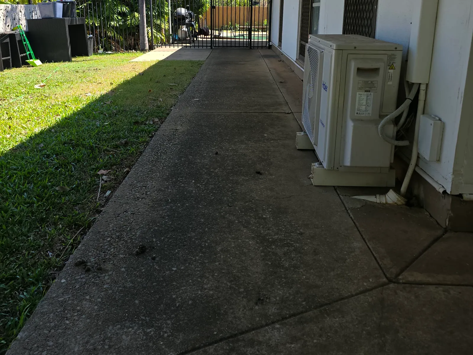 Dark, mould-stained concrete path before pressure cleaning